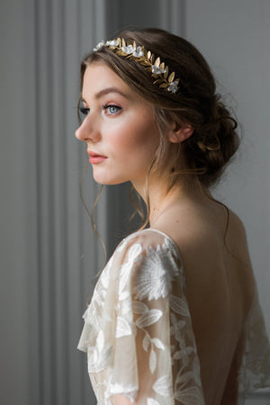 Bride wearing a crown heapiece made of gold leaves and silk flowers