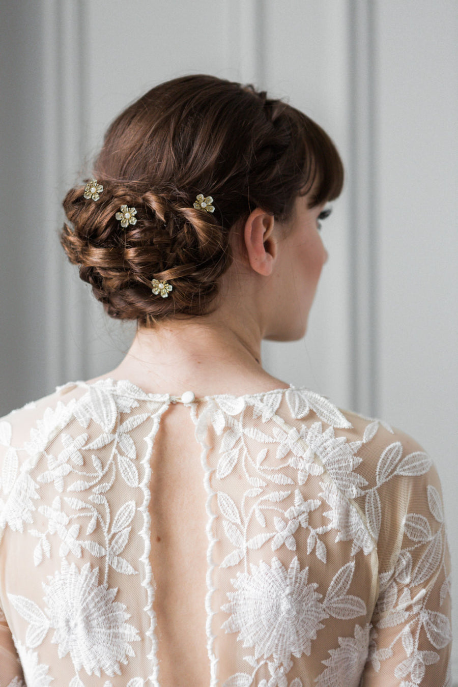 Model with hair pins in her bun wearing a wedding dress