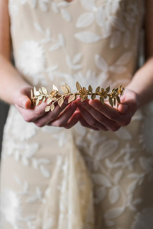 Bride holding a gold leaf bridal tiara