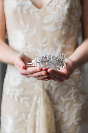 Bride holding a silver leaf headband