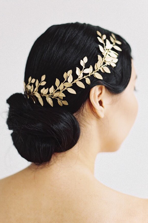 Model in a wedding dress wearing a gold leaf wrap headpiece