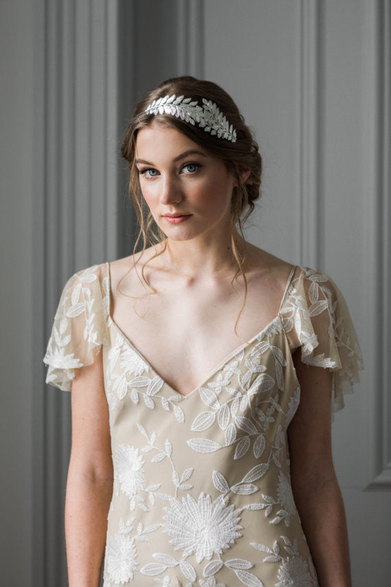 Model wearing a bridal headpiece made of silver leaves