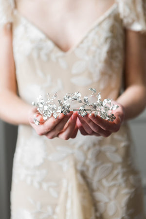 Bride holding a silver headpice made replica antique myrtle leaves