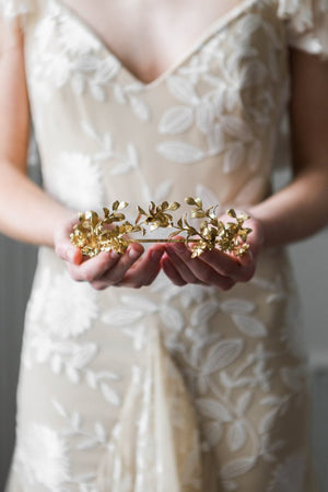 Bride holding a gold headpice made replica antique myrtle leaves