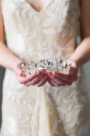 Bride holding a silver laurel leaf tiara