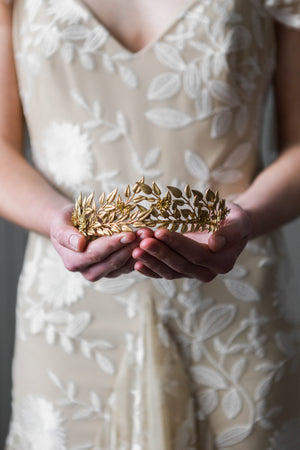 Bride holding a gold edwardian leaf tiara
