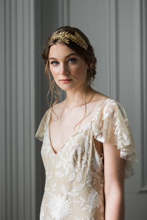 Model wearing a bridal headpiece made of gold leaves