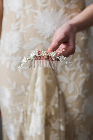Bride holding a crystal and flower hair comb