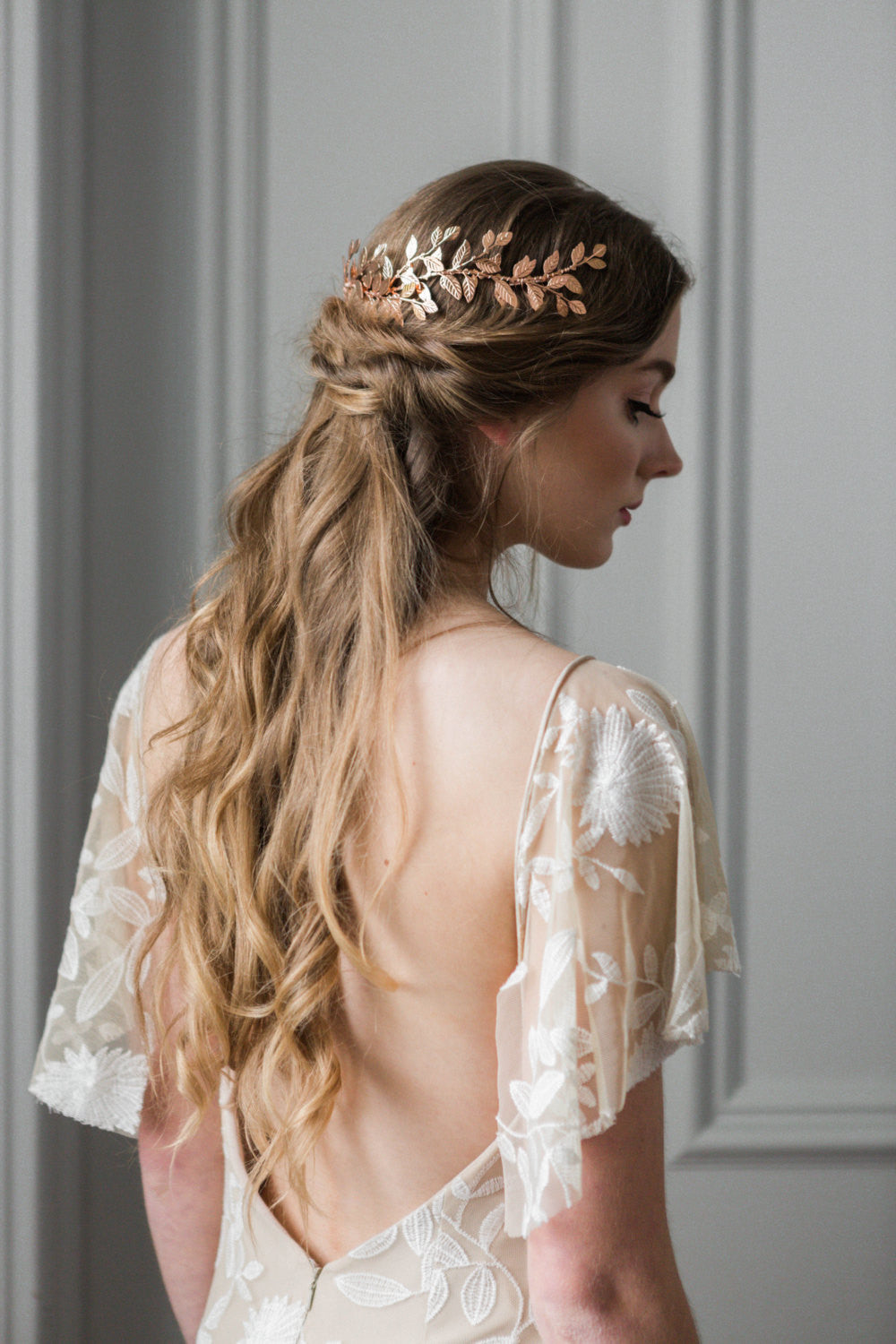 Model in a wedding dress wearing a gold leaf wrap headpiece