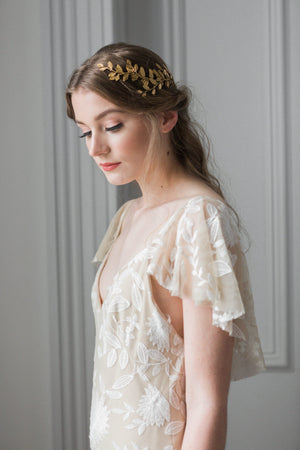 Model wearing a gold laurel leaf bridal headpiece on the back of her head