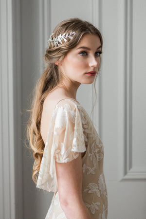 Model in a wedding dress wearing a silver leaf wrap headpiece