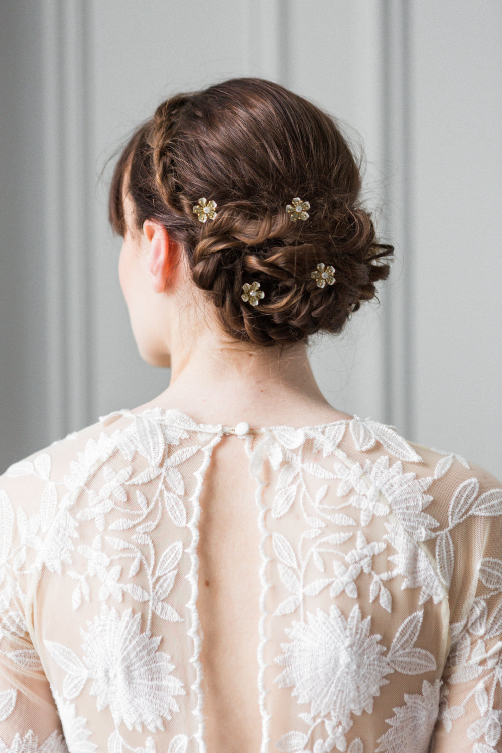 Model with hair pins in her bun wearing a wedding dress
