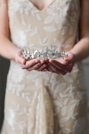 Bride holding a silver leaf bridal tiara