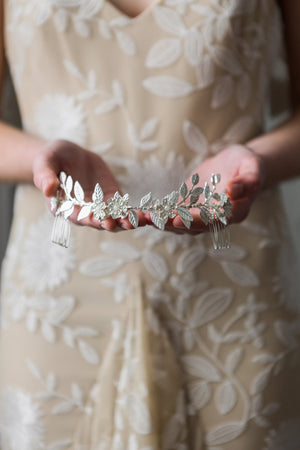 Bride holding a headpiece made of silver leaves