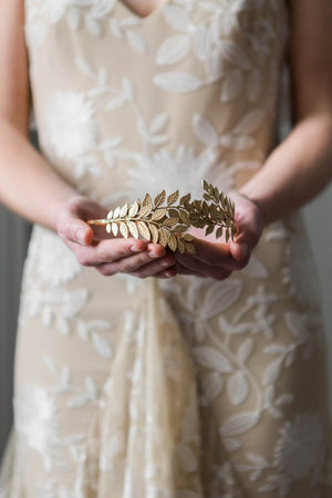 Bride holding a gold leaf headband