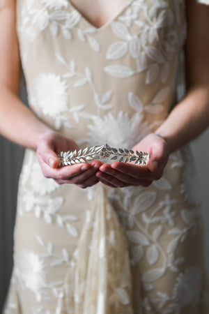Bride holding a silver edwardian leaf tiara