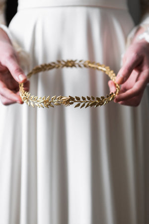 Bride holding a gold edwardian leaf circlet crown