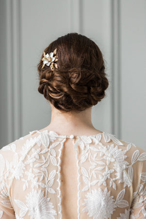 Model in a wedding dress wearing a bridal flower comb