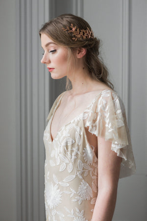 Model in a wedding dress wearing a gold leaf wrap headpiece