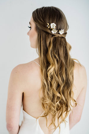 Bride wearing a hair comb made of gold leaves and ivory flowers