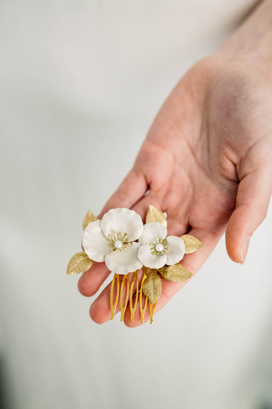 Bride wearing a bridal hair comb made of gold and ivory flowers