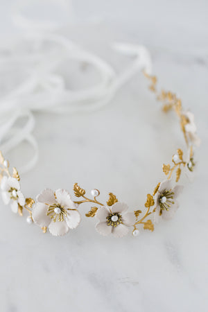 close up of a headpiece made of gold leaves and ivory flowers