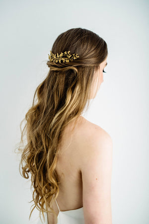 Bride wearing a hair comb headpiece made of gold leaves