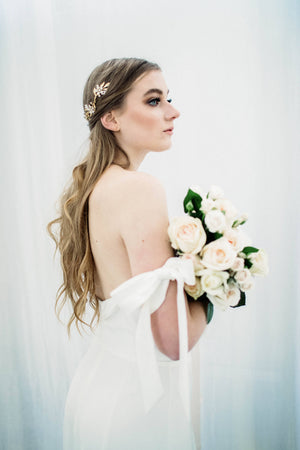 Model in wedding dress wearing a gold and crystal bridal tiara
