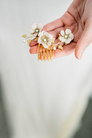 Close up of a hair comb made of gold leaves and ivory flowers