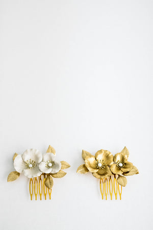Close up of two bridal hair combs made of gold and ivory flowers