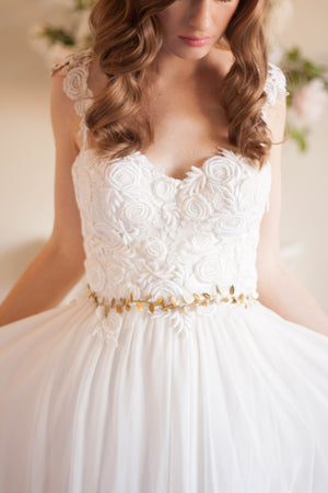 Bride in a wedding dress wearing a silver leaf sash